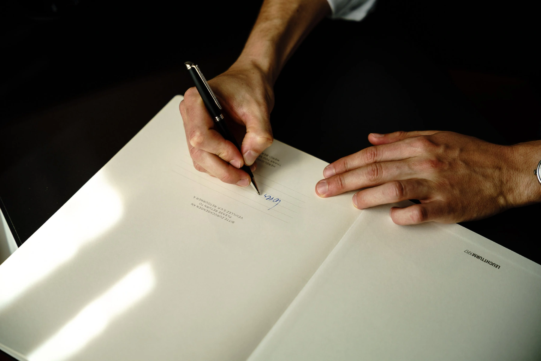 Nahaufnahme einer Person, die ein offizielles Dokument unterschreibt – Symbolbild für rechtliche Formalitäten bei öffentlichen Ausschreibungen.